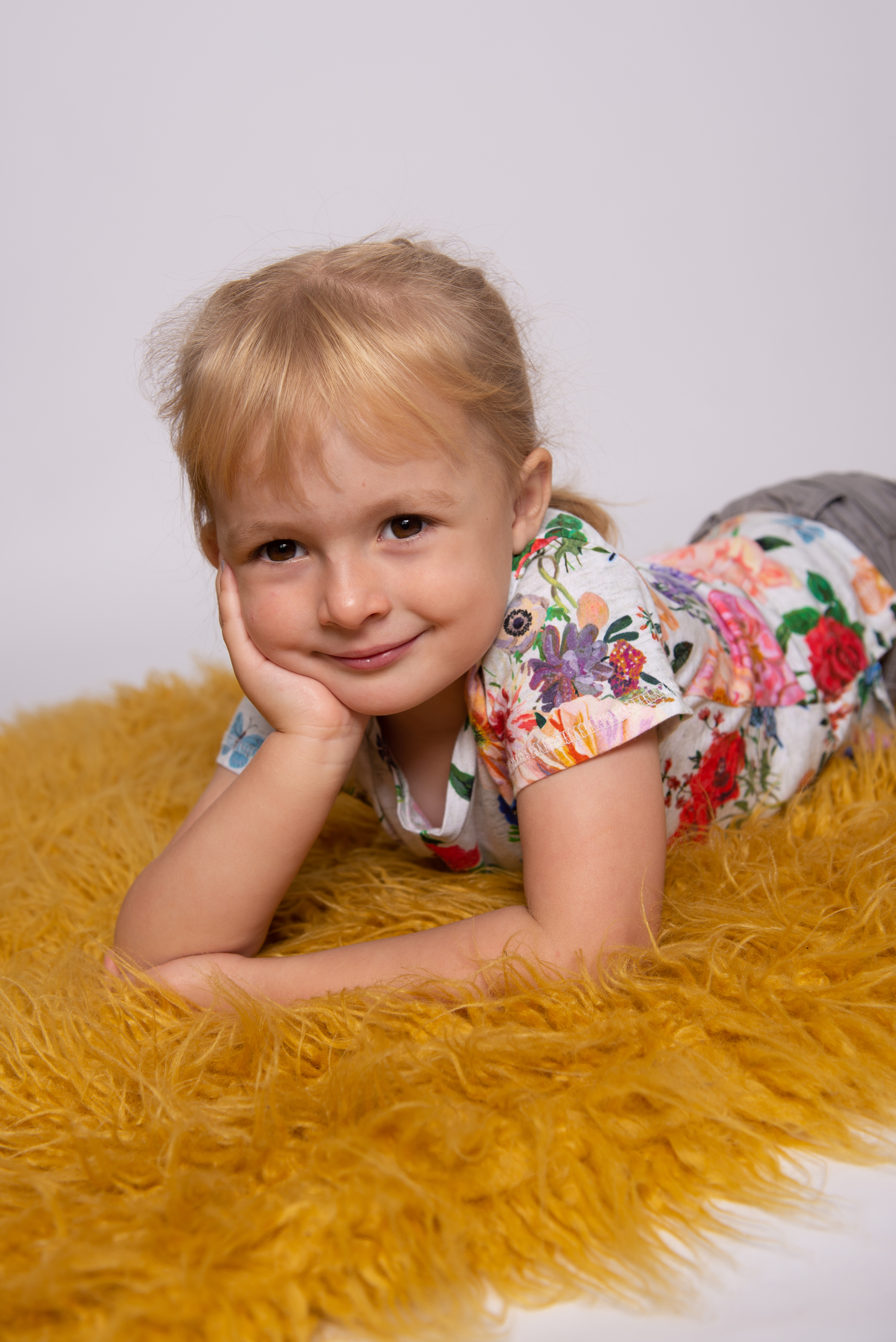 girl on yellow mat leaning on elbows 